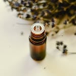 Brown and White Bottle Beside Dried Leaves